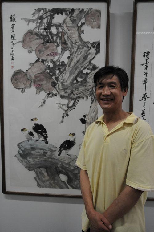 【陕西长安书画艺术研究院副院长罗金保在展览作品前留影】