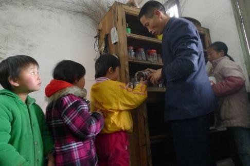 孩子们排队等着陆国军给大家分水，认真工作中